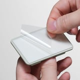 Osoba držící elegantní, stříbrný odpadkový koš s průhledným víkem, zdůrazňující jeho moderní, čistý design.