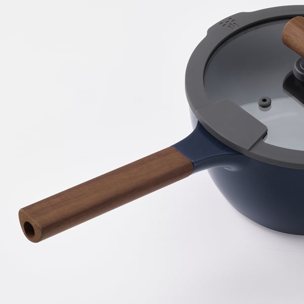 Moderní rendlík s dřevěnou rukojetí a skleněnou poklicí.