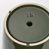 Detail dna zelených nádob s reliéfním číslem 15 a odtokovým otvorem, který ukazuje kvalitní design a praktické detaily.