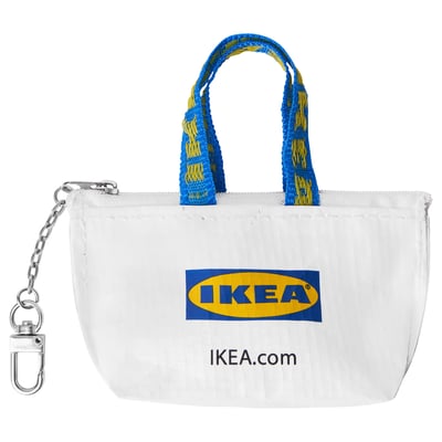 Mini pouzdro Ikea KNÖLIG. Bílá barva s modrým zipem a madly. Kovový přívěsek na klíče. Bezpečně drží malé předměty.