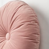 Přispějte měkkým kulatým polštářkem s centrálním knoflíkem, který dává vyniknout kvalitní struktuře a designu.