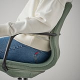 Osoba sedící na kancelářské židli LÅNGFJÄLL, s výškově nastavitelným sedákem a bederní opěrkou pro pohodlí.