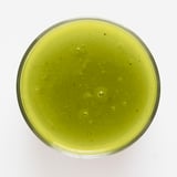 Jasně zelené smoothie LÅNGLUR ve skleněné nádobě, hladká textura, příchuť jablek a fenyklu.