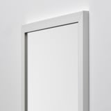 Na světlé stěně visí zrcadlo s bílým rámem, které odráží kvalitu a moderní design.