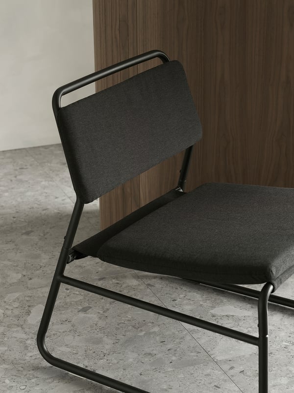 Moderní černá židle s šedým čalouněním, elegantní kovový rám, minimalistický design.