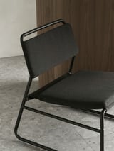 Moderní černá židle s šedým čalouněním, elegantní kovový rám, minimalistický design.