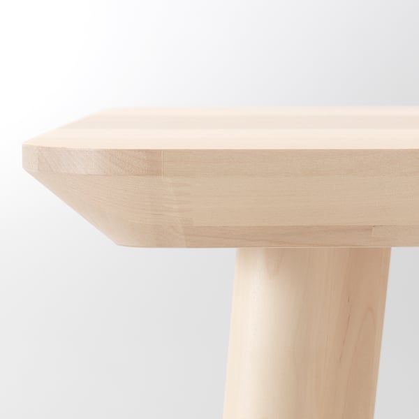 Detailní záběr na hladkou, světle zbarvenou dřevěnou desku stolu s jasnými, rovnoměrnými kresbami, která předvádí její přirozenou povrchovou úpravu a vysoce kvalitní řemeslné zpracování.