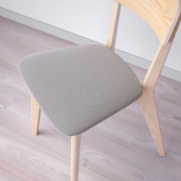 Moderní dřevěná židle se zakřiveným opěradlem, s plyšovým látkovým sedákem, posazená na světlé dřevěné podlaze.