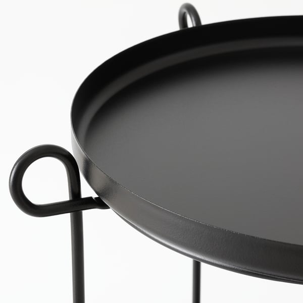 Moderní černý odkládací stolek se dvěma odnímatelnými přihrádkami, podepřenými robustními, minimalistickými kovovými nohami.
