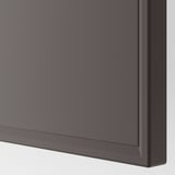 Detailní pohled na hladké, šedé, zkosené dveře skříně.