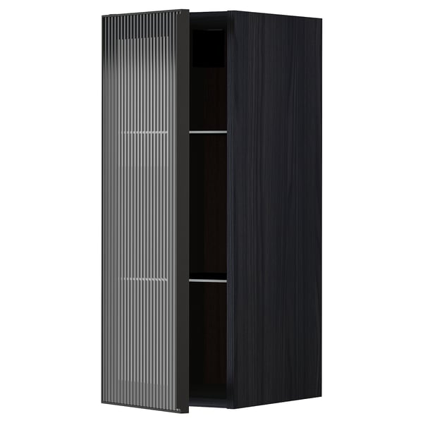 Moderní černá kuchyňská skříňka s jednoduchými dvířky z rákosového skla a elegantním kovovým rámem, stojící vzpřímeně s minimalistickým designem.