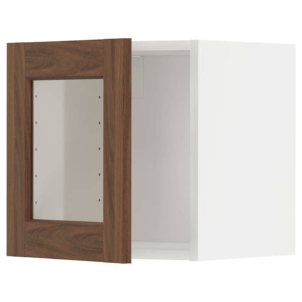Kuchyňská skříňka METOD se skleněnými dvířky v ořechovém provedení a bílým interiérem, která nabízí moderní a hřejivý design.