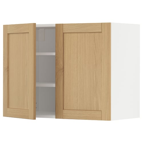 Kuchyňská nástěnná skříňka METOD s dvířky ze světlého dubu. Má rámovaný design se zkosenými hranami. Jedny dveře jsou otevřené a odhalují vnitřní police.