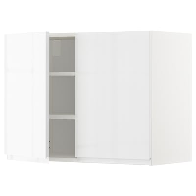 Bílá kuchyňská skříňka METOD s lesklým povrchem a stříbrnými úchytkami. Stojí samostatně s elegantním obdélníkovým designem.