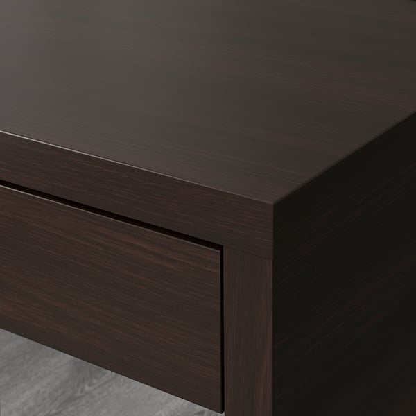Moderní psací stůl z tmavého dřeva s elegantními hranami a otvorem pro vedení kabelů na zadní straně, který ukazuje kvalitní řemeslné zpracování.