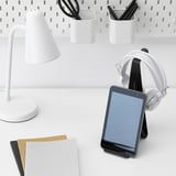Stůl se stojanem na tablet pro telefon a sluchátka, lampu, papíry a úložné nádoby.