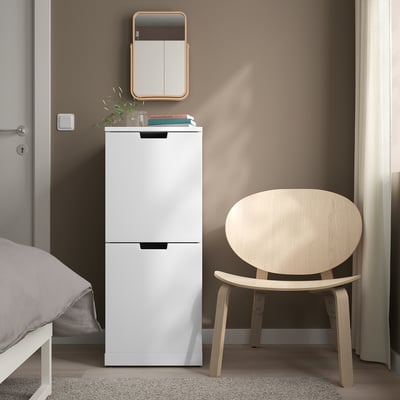 Bílá IKEA NORDLI komoda se 2 zásuvkami mezi postelí a židlí, minimalistický roh.