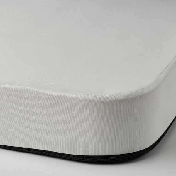 Detailní pohled na vysoce kvalitní bílou matraci se silným černým okrajem a zipem, která předvádí její odolný a pohodlný design.