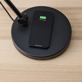 Černá lampa bezdrátově nabíjí smartphone na 88%.
