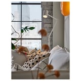 Útulná ložnice s výhledem na město, postel, lampa, rostlina.