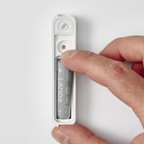 Ruce při instalaci ladda baterie do senzoru PARASOLL pro chytrou domácnost, zajišťující monitoring dveří/oken.