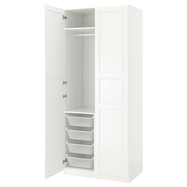 Bílá šatní skříň ikea PAX s otevřenými dveřmi, odhalujícími kovovými síťovanými koši a věšící policí uvnitř.