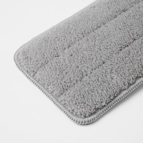 Detailní záběr měkké, světle šedé látky z mikrovlákna na bílém pozadí, která ukazuje její texturu a vysokou kvalitu.
