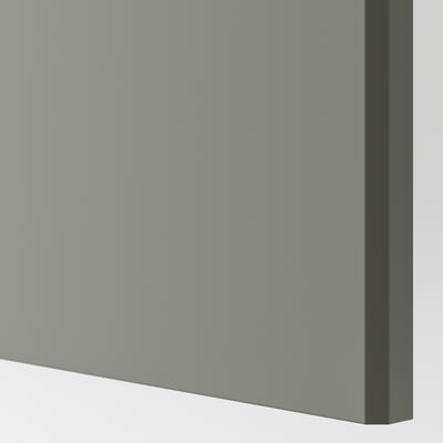 Detail hladkých, minimalistických, jemně šedozelených dveří se zaoblenými hranami, které zdůrazňují recyklovaný a ekologický materiál.