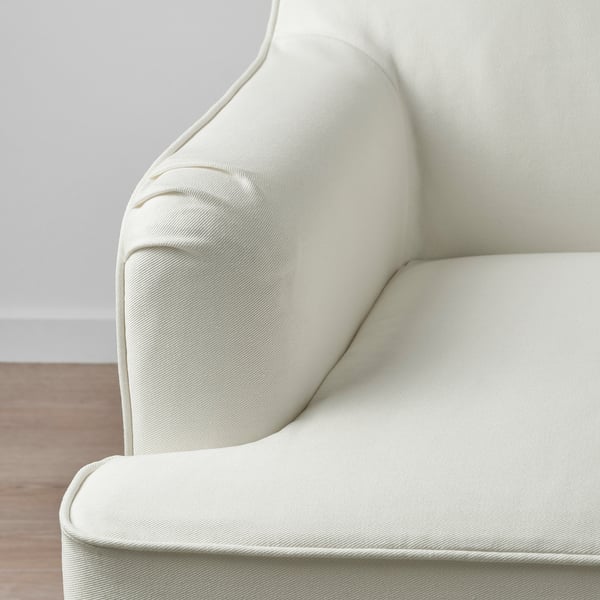 Detailní záběr na pohodlnou, bílou, texturovanou látkovou pohovku, která se vyznačuje vysoce kvalitním designem a pohodlím.