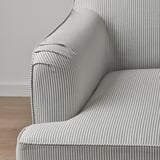 Detailní záběr pruhované, strukturované látky na stylové, polstrované židli s ozdobným lemováním a čistými liniemi.