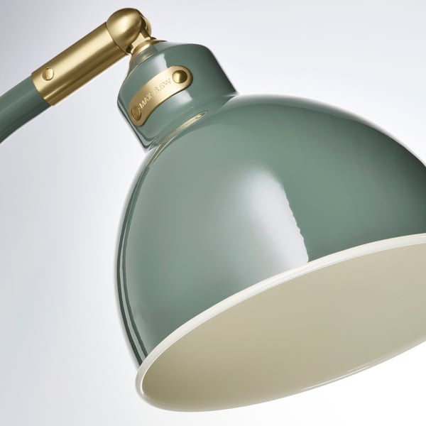 Stolní lampa se zeleným stínidlem a nastavitelným ramenem.