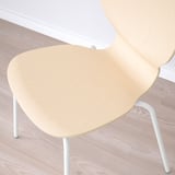 Minimalistická židle ze světlého dřeva s bílými kovovými nohami, navržená pro pohodlí a moderní estetiku.