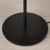 Moderní černý podstavec stojací lampy na podlaze ze světlého dřeva, elegantní design, kvalitní materiály.
