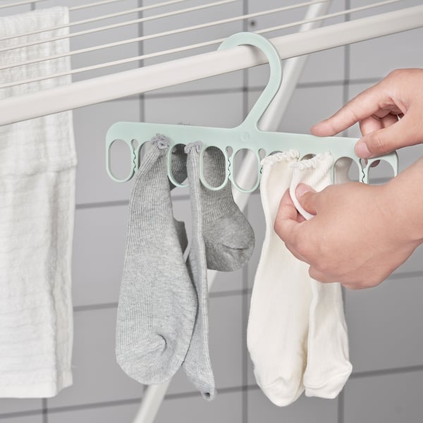 Ručně věší ponožky na ramínko mátové barvy s několika smyčkami.