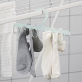 Ramínko s několika smyčkami drží šedé a bílé ponožky na sušení, což ukazuje snadnou organizaci.