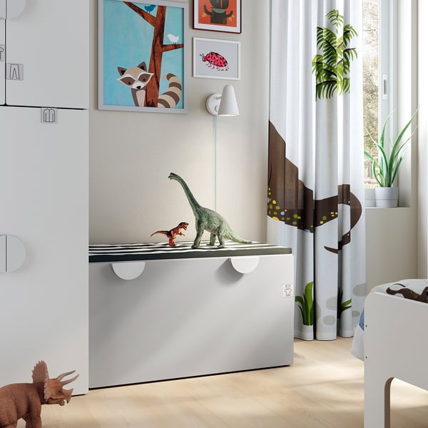 Dětský pokoj s dinosauřími hračkami na bílé lavici SMÅSTAD, moderně zařízený a s velkým oknem.