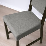Detail sedáku a opěradla moderních židlí, čalouněných šedou látkou. Kovový rám je elegantní a robustní, což zajišťuje pohodlí a odolnost.