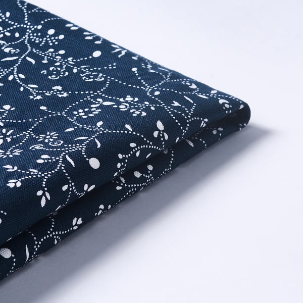 Skládaná tmavě modrá látka s bílým květinovým vzorem, vysoce kvalitní design a textura.