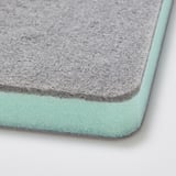 Detailní záběr oboustranné čisticí houbičky s měkkým mátově zeleným a hrubě šedým povrchem, který předvádí její texturovanou kvalitu.