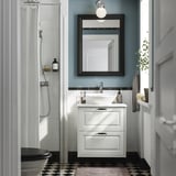 Bílá toaletní stolek TÄNNFORSEN s umyvadlem, zrcadlem, sprchou a úložným prostorem.