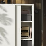 Otevřená bílá skříň TONSTAD s černými a dřevěnými úložnými boxy. Police nastavitelné, čistý design.