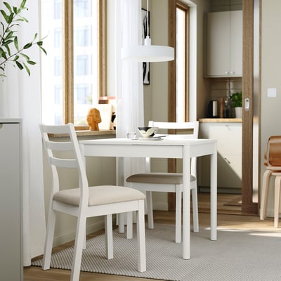 Malý bílý jídelní set s rozkládacím stolem, dvěma polstrovanými židlemi a minimalistickým designem.