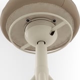 Srozumitelná spodní strana polstrované kancelářské židle, zobrazující robustní kovové mechanismy a krémovou kůži.