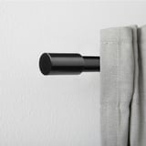 Černá hliníková válcová koncovka na záclonové tyči, moderní design. Malý, elegantní a minimalistický.
