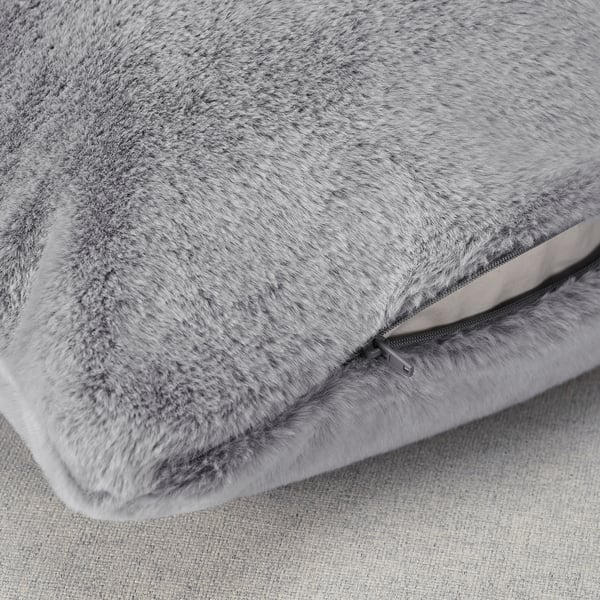 Detailní záběr měkkého, plyšového šedého polštáře se zipem, který předvádí pocit luxusu a kvality.