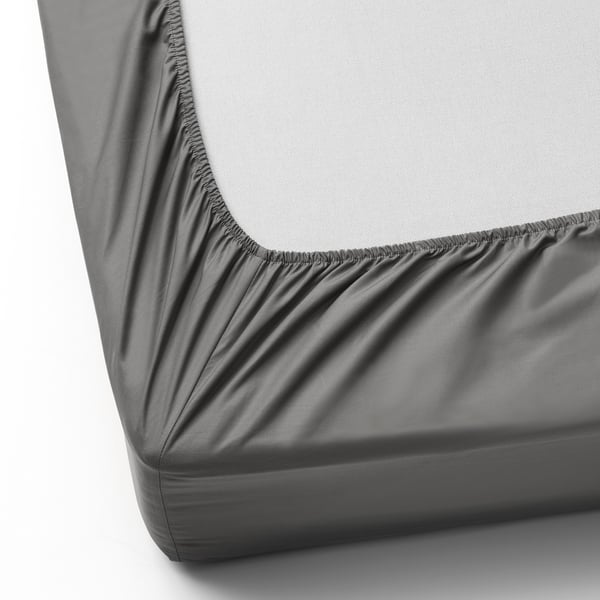 Detail rohu na přiléhavém prostěradle, viditelné elastické okraje. Díky svému roztažitelnému designu se hodí na silné matrace.