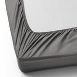 Detail rohu na přiléhavém prostěradle, viditelné elastické okraje. Díky svému roztažitelnému designu se hodí na silné matrace.