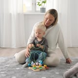 Žena a dítě si hrají s dřevěnou hračkou UPPSTÅ, učí se barvy a tvary