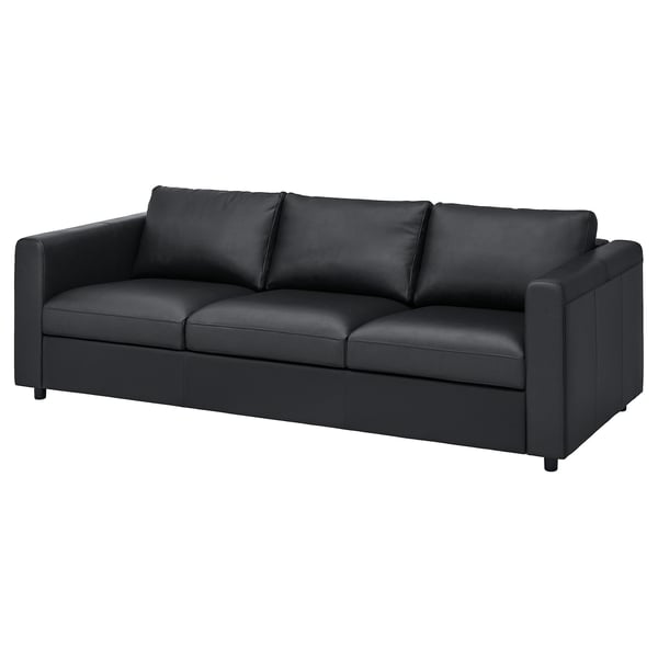 Moderní černá kožená pohovka s čistými liniemi, polstrovanými polštáři a minimalistickým designem. Vhodné do moderních obývacích pokojů.
