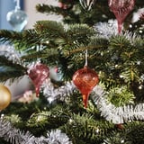 VINTERFINT červené skleněné ozdoby na zeleném vánočním stromku.